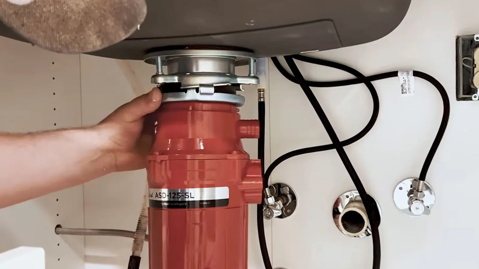 Garbage disposal unit being installed under a sink