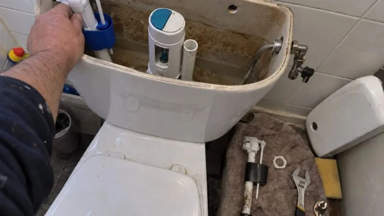 Technician repairing a toilet fill valve