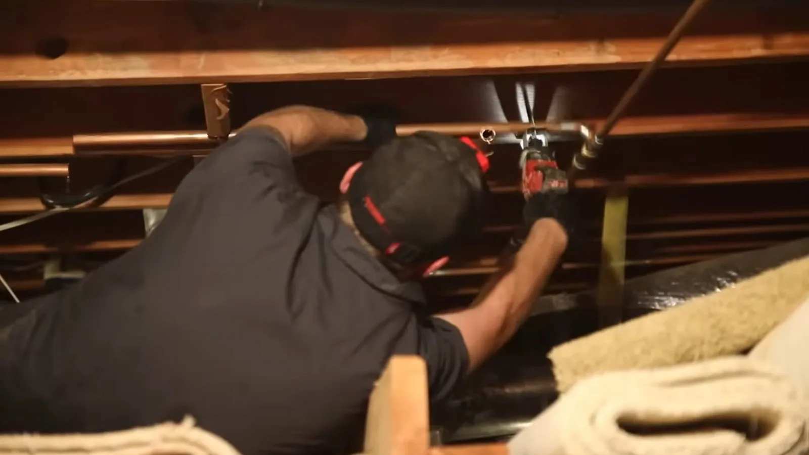Technician repairing a water line in a crawlspace
