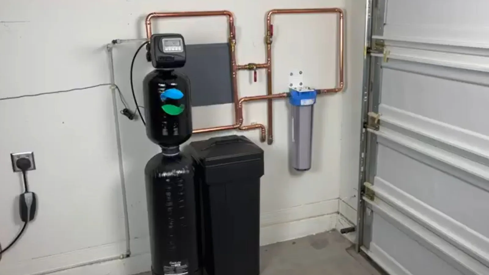Residential water softener system installed in a garage